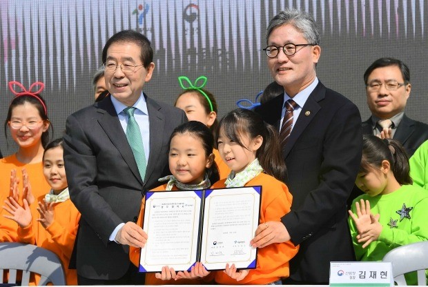 박원순 서울시장(왼쪽)과 김재현 산림청장이 23일 서울 중구 만리동 광장에서 열린 '서울시-산림청 미세먼지 저감 및 품격 있는 도시를 위한 업무협약 체결식에서' 협약서에 서명 후 아이들과 함께 기념촬영을 하고 있다. 서울시와 산림청은 도심에 도시숲을 늘리는 업무협약을 체결했다. 김범준 기자 bjk07@hankyung.com