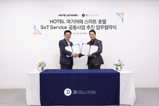 서무정 HOTEL여기어때 부대표(왼쪽)와 제영호 제이디솔루션 대표(오른쪽)가 협약 체결 후 악수하고 있다. HOTEL여기어때 제공