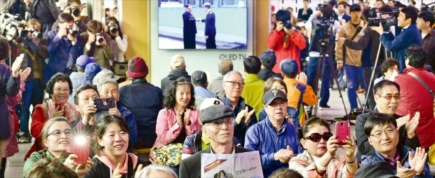 < 남북 정상 만남에 쏠린 눈 > 남북한 정상회담 생중계 방송을 보려고 서울역 1층 대합실에 모여든 시민들이 27일 오전 9시29분께 문재인 대통령과 김정은 북한 국무위원장이 판문점 군사분계선(MDL)에서 악수하는 것을 지켜보며 환호하고 있다. 북한 최고지도자가 MDL을 넘어온 건 이번이 처음이다. 신경훈 기자 khshin@hankyung.com