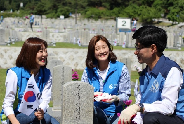 신한은행 임직원과 가족 430여명은 지난 19일 서울 동작구 소재 국립 현충원에서 자원봉사를 실시했다. 임직원들이 자원봉사 활동 중 환하게 웃고 있다.