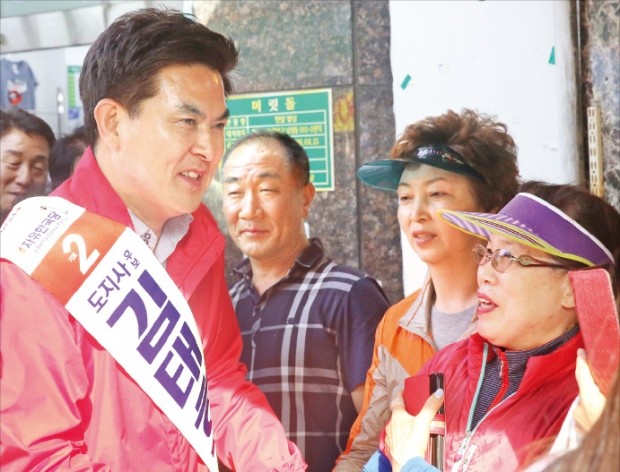 김태호 자유한국당 경남지사 후보(왼쪽)가 지난달 31일 경남 창원 마산어시장에서 한 상인과 악수하며 지지를 호소하고 있다.   김해연 기자 