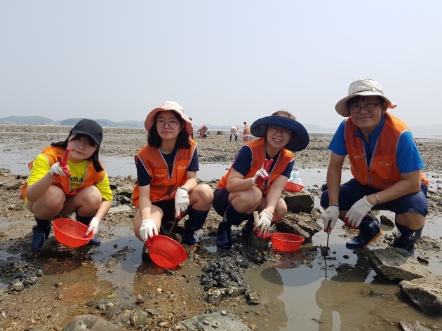 이광식 코스콤 정보사업실 과장(맨 오른쪽) 가족들이 지난 28일 경기도 안산 흘곶마을에서 어촌 환경정화 봉사활동 및 갯벌체험을 진행한 뒤 환하게 웃고 있다. 사진=코스콤﻿

