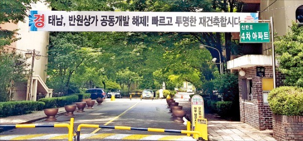 서울 서초구 ‘신반포4차’ 단지 정문에 인근 상가 건물과의 통합 재건축안을 취소한 서울시 결정을 환영하는 플래카드가 걸려 있다. /선한결 기자 