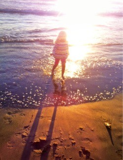  햇살이 반짝이는 샌타모니카 해변에서 물놀이를 즐기는 소녀 
 