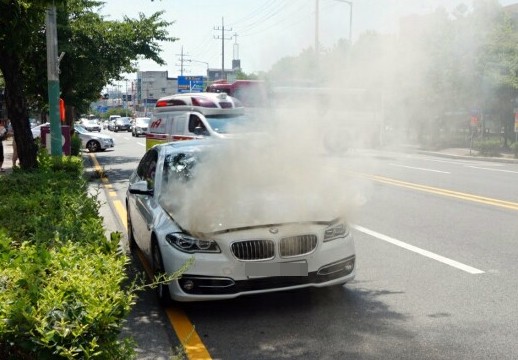 4일 오후 2시 15분께 목포시 옥암동 한 대형마트 인근 도로에서 주행 중인 2014년식 BMW 520d 승용차 엔진룸에 불이 나 연기가 치솟고 있다. 경찰과 소방 당국은 결함 등 화재 원인을 파악하고 있다. [사진=연합뉴스]