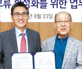 노진호 한컴 대표(왼쪽)와 염무웅 겨레말큰사전남북공동편찬사업회 이사장이 23일 업무협약 후 기념촬영하고 있다.  /한컴 제공 