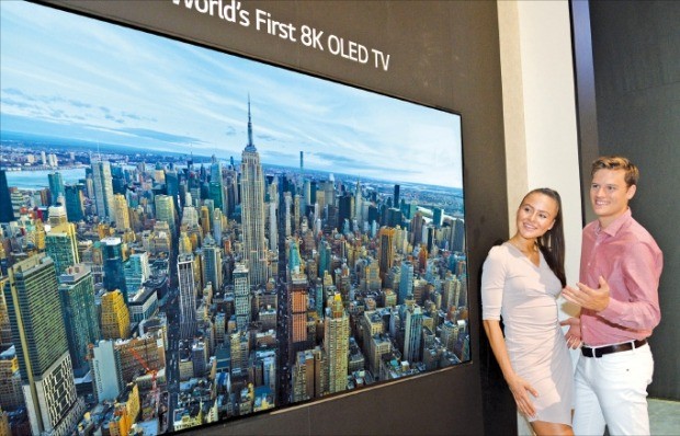 LG전자 모델들이 세계 최초 8K 올레드 TV를 살펴보고 있다.  /LG전자 제공 