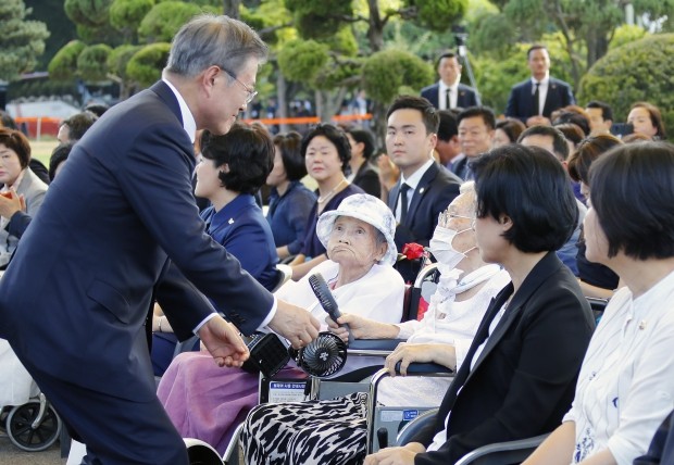 문재인 대통령이 14일 충남 천안 국립 망향의 동산에서 열린 일본군 위안부 피해자 기림의 날 기념식에 입장하며 김경애 할머니와 인사를 나누고 있다. /사진=연합뉴스