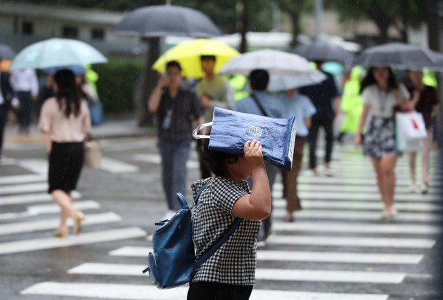 비가 쏟아진 3일 오전 서울 종로구 정부서울청사 인근 도로에서 시민들이 출근을 서두르고 있다. [사진=연합뉴스]