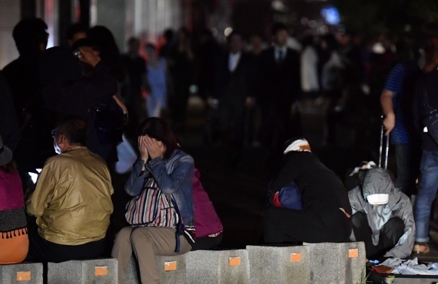 일본 북단 홋카이도 남쪽에서 6일 새벽 3시 8분께 규모 6.7의 지진이 발생했다. 사진은 이날 지진으로 정전이 발생한 삿포로 시내에서 시민들이 피곤한 모습으로 길가에 앉아 있는 모습. [사진=연합뉴스]