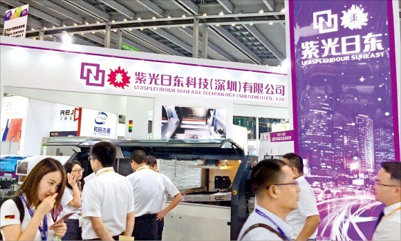 지난달 중국 선전에서 열린 국제전자생산설비 전시회에서 관람객들이 칭화유니의 전시 제품을 둘러보고 있다.  /노경목 특파원 