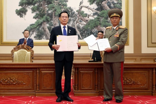 지난 19일 오전 평양 백화원 영빈관에서 문재인 대통령과 김정은 국무위원장이 지켜보는 가운데 송영무 국방부 장관과 북한 노광철 인민무력상이 판문점 선언 이행을 위한 군사분야 합의문에 서명한 뒤 교환하고 있다. 사진=연합뉴스