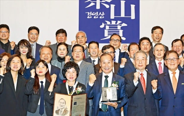 4일 한국경제신문사 다산홀에서 열린 제27회 다산경영상 시상식에서 창업경영인 부문 수상자인 최병오 패션그룹형지 회장(앞줄 왼쪽 네 번째)과 부인 박종길 씨(세 번째)가 수상을 축하하기 위해 참석한 임직원 및 지인들과 함께 파이팅을 외치고 있다. /강은구 기자 egkang@hankyung.com