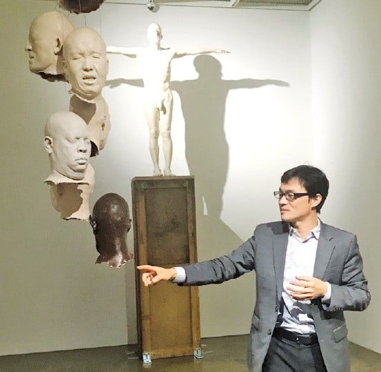 한효석 인천대 교수가 서울 통의동 아트사이드갤러리에 전시된 자신의 작품 ‘누가 이 아름다운 세상을 지옥으로 만들었는가!’를 설명하고 있다.  
