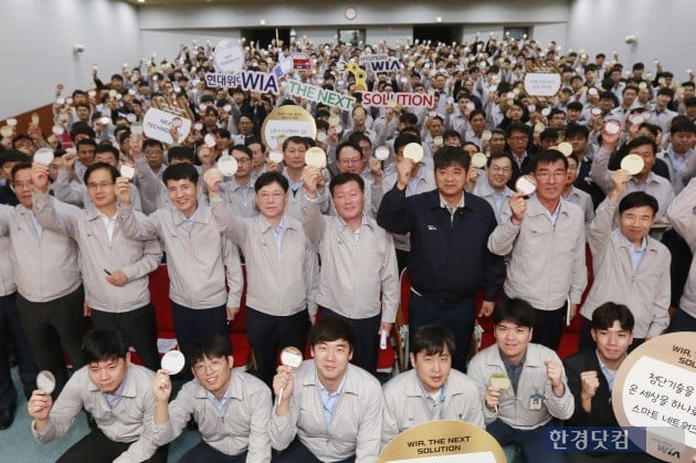 김경배 현대위아 사장(두번째 줄 오른쪽 네번째)과 손성환 현대위아 노동조합 지회장(두번째 줄 오른쪽 세번째) 등 임직원들이 1일 경남 창원시 성산구 현대위아 본사 대강당에서 열린 '비전 결의 대회'에서 각자의 미래 비전을 적은 '비전카드'를 들어 보이고 있다. (사진=현대위아)

 
