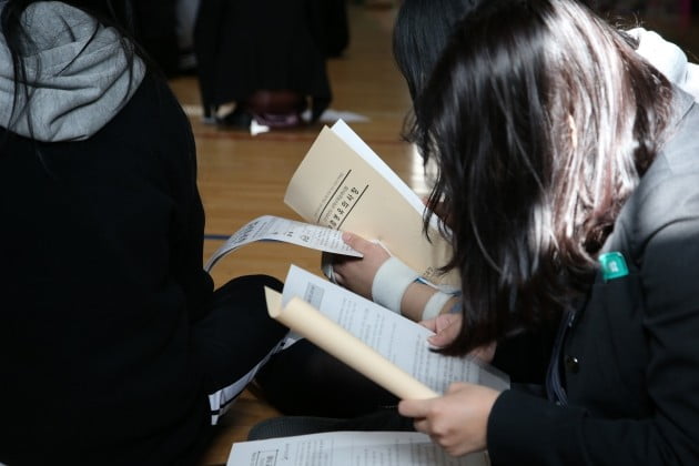 대학수학능력시험을 하루 앞둔 14일 경북 포항 장성고에서 예비소집에 모인 이 학교 학생들이 유의사항이 적힌 책자를 보고 있다.  [사진=연합뉴스]