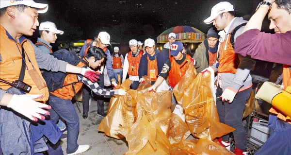 한화그룹 임직원들이 ‘서울세계불꽃축제 2018’을 마친 뒤 주변을 청소하고 있다.  /한화그룹 제공
 