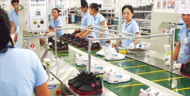 태광실업 베트남 목바이 공장 생산라인에서 근로자들이 제품을 검사하고 있다.   /한경DB 