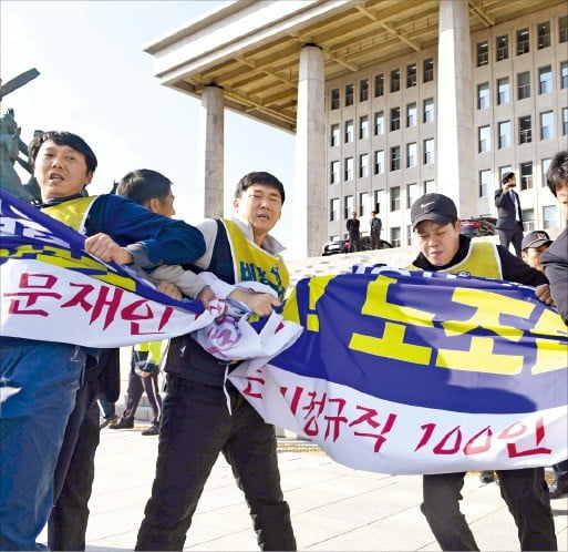 민주노총은 14일 서울 시내 41곳에서 동시다발 시위를 했다. 청와대 앞에서 민주노총 지도부가 시국 농성에 들어가겠다고 선언하고 있다.(위) 민주노총 조합원들이 국회의사당 앞에서 현수막을 펼치자 이를 제지하는 국회 직원과 몸싸움을 벌이고 있다.(아래)  /김영우·허문찬 기자 youngwoo@hankyung.com