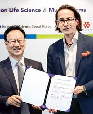 이우석 코오롱생명과학 대표(왼쪽)와 라만싱 먼디파마 대표가 ‘인보사’의 일본 수출 계약서를 들어보이고 있다. /코오롱생명과학 제공  
 