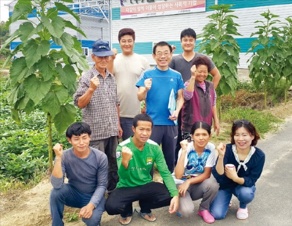 김영균 한국에코팜 대표(맨 뒷줄 오른쪽)와 직원들이 회사 농장 앞에서 파이팅을 외치고 있다.  /한국에코팜 제공 