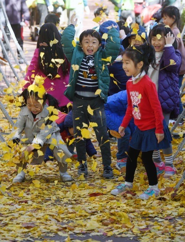 2일 서울 석촌호수에서 열린 '2018 잠실 석촌호수 단풍·낙엽축제'에서 어린이들이 은행잎을 던지며 가을을 만끽하고 있다. 
