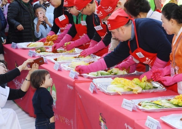 2일 서울시청 앞 서울광장에서 열린 '제5회 김장문화제'에서 서울시 홍보대사인 샘 헤밍턴이 아들에게 배추를 건네고 있다.이날 만든 165톤의 김장김치는 어려운 이웃들에게 전달된다. 강은구기자 egkang@hankyung.com



2018.10.2  