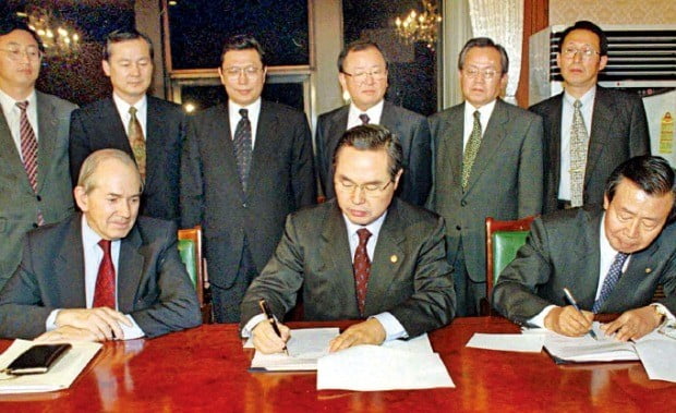 1997년 12월3일 미셸 캉드쉬 국제통화기금(IMF) 총재(앞줄 왼쪽)가 지켜보는 가운데 임창열 부총리 겸 재정경제원 장관(가운데)과 이경식 한국은행 총재가 구제금융 합의문에 서명하고 있다. /한경DB  