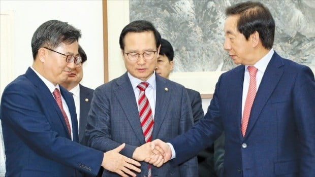 홍영표 더불어민주당 원내대표(가운데)와 김성태 자유한국당 원내대표(오른쪽)가 김동연 부총리 겸 기획재정부 장관(왼쪽)과 함께 6일 국회에서 내년도 예산안 합의 결과를 발표한 뒤 손을 잡고 있다. /연합뉴스 