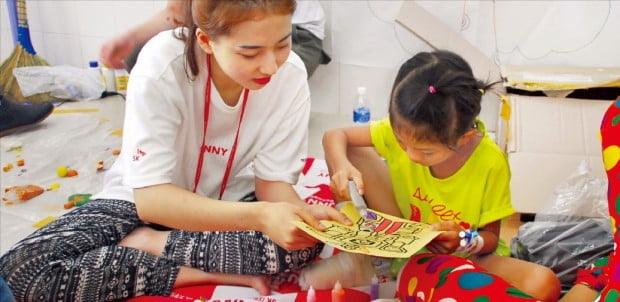 행복나눔재단의 대학생 자원봉사단 ‘SK 써니’ 단원이 베트남 안면기형 어린이와 함께 놀이학습을 하고 있다. SK그룹 제공