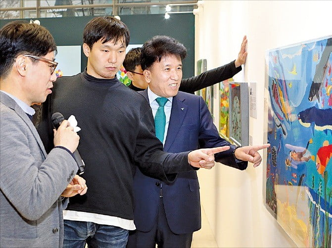 지난 3일 서울 을지로 사옥 로비에서 열린 자폐성 장애작가 작품 전시회에서 함영주 KEB하나은행장(오른쪽)이 안윤모 작가(왼쪽)로부터 작품 설명을 듣고 있다.  KEB하나은행  제공 