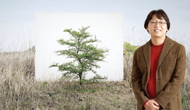 이명호 씨가 갤러리 현대에 전시된 ‘나무’ 시리즈를 설명하고 있다.  