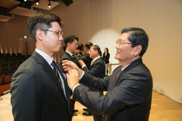 차남규 한화생명 부회장이 2019년 신입사원들에게 사령장 수여와 함께 회사 배지를 달아주고 있다.(사진=한화생명)