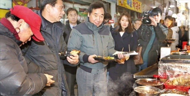 < 통인시장 간 이낙연 총리 > 이낙연 국무총리(왼쪽 세 번째)가 4일 서울 종로구 통인시장을 방문해 이곳의 명물인 엽전 도시락을 체험하고 있다. 이 총리는 전통시장 경기를 체감하고 상인들의 어려움을 듣기 위해 통인시장을 찾았다.    /김범준 기자 bjk07@hankyung.com 