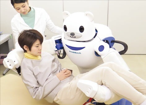 일본 이화학연구소가 개발한 간병로봇 ‘로베아’가 앉아 있는 사람을 안아올리는 동작을 시연하고 있다.   /이화학연구소  제공 