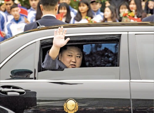< 손 흔들며…벤츠 타고 하노이로 > 김정은이 자신의 전용 차량을 탄 채 환영단에게 손을 흔들고 있다. 