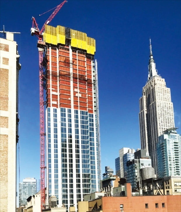 미국 뉴욕 맨해튼 노매드 지역에 건설 중인 고급형 콘도미니엄 ‘매디슨 하우스’. 약 250m 높이로 설계된 초고층 타워로 내년 6월께 완공될 예정이다. 매디슨 하우스 오른쪽에 엠파이어 스테이트 빌딩이 자리잡고 있다. /JD칼라일 제공 