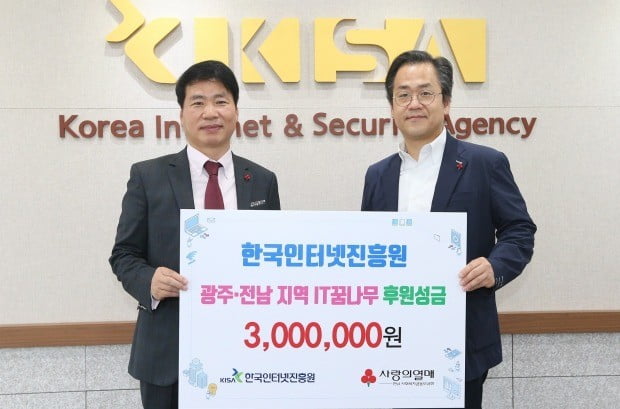 이성수 KISA 경영기획본부장이 김상균 전남사회복지공동모금회 사무처장(왼쪽)에게 성금을 전달하며 기념사진을 찍고 있다. 