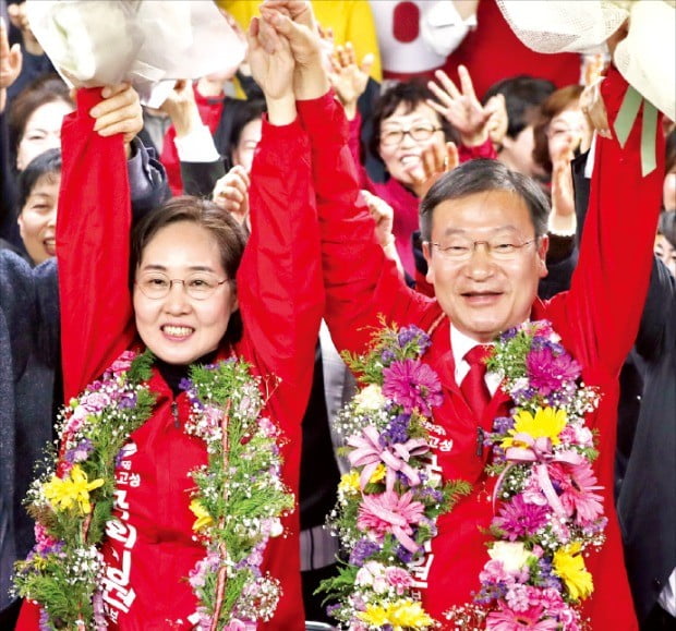 정점식 자유한국당 당선자(오른쪽)가 4·3 보궐선거 통영고성 선거구에서 승리한 뒤 선거 사무실에서 지지자들과 손을 맞잡아 올리며 환호하고 있다. 왼쪽은 부인 최영화 씨.  /연합뉴스 