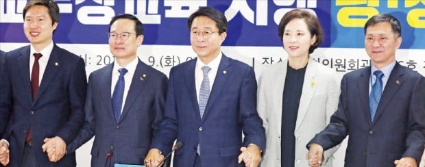 9일 오전 국회 의원회관에서 열린 고교 무상교육 시행 관련 당·정·청 협의회에서 더불어민주당 김해영 최고위원(왼쪽부터), 홍영표 원내대표, 조정식 정책위원회 의장, 유은혜 부총리 겸 교육부 장관, 김연명 청와대 사회수석 등이 손을 맞잡고 있다.  /연합뉴스 