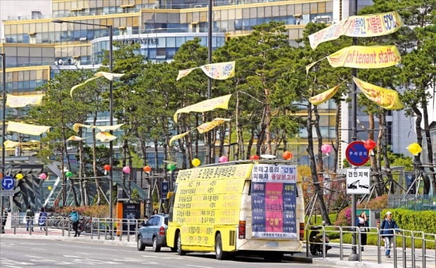 거리에 나부끼는 시위 현수막이 도시 경관을 해치는 주범으로 꼽히고 있다. 18일 서울 잠실역 주변에 가로등 사이를 긴 줄로 연결해 매단 현수막들이 바람에 휘날리고 있다. 현수막에는 영어와 일본어까지 동원해 롯데그룹을 비난하는 내용이 담겨 있다.  /신경훈 기자 khshin@hankyung.com 