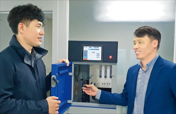 이엠씨의 염은성 대표(오른쪽)와 최민규 부장이 수질의 유기물질 오염도를 측정하기 위한 장비인 TOC 분석기에 대해 설명하고 있다.  /김낙훈 기자
 