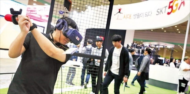 < 홈런 쳤나요? > ‘월드IT쇼 2019’를 찾은 한 관람객이 SK텔레콤 전시관에서 야구 방망이를 휘두르며 가상현실(VR) 야구게임을 체험하고 있다.  /연합뉴스  