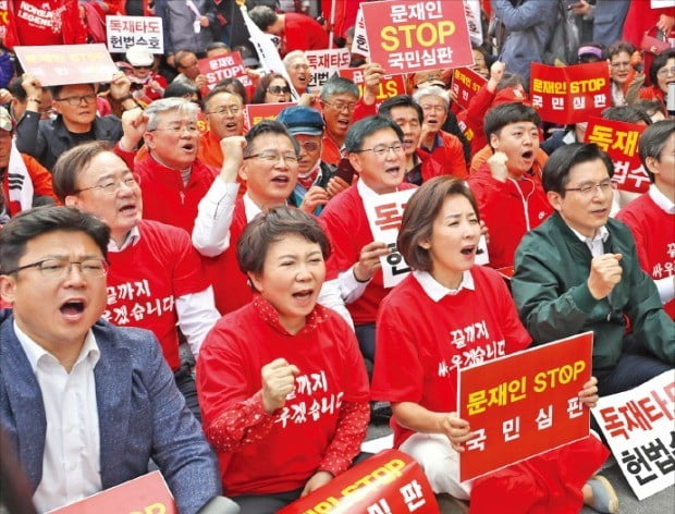 황교안 자유한국당 대표(앞줄 오른쪽 첫 번째)와 나경원 원내대표(두 번째)가 한국당 의원들과 함께 지난 27일 서울 광화문광장에서 열린 집회에 참석해 구호를 외치고 있다.  /연합뉴스 