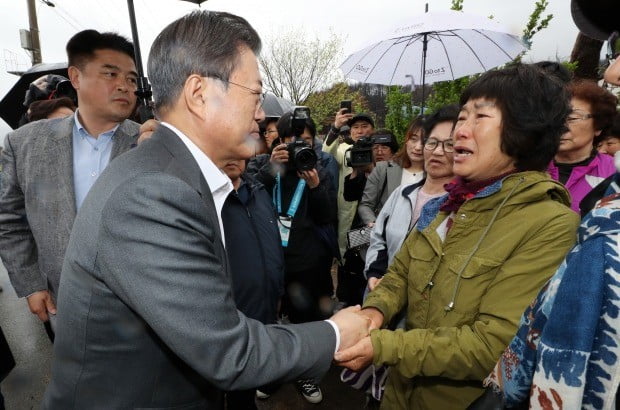  문재인 대통령이 26일 오전 강원도 산불피해 복구현장인 강원도 고성군 토성면을 찾아 복구현장을 살펴본 뒤 이재민들을 위로하고 있다. 사진=연합뉴스