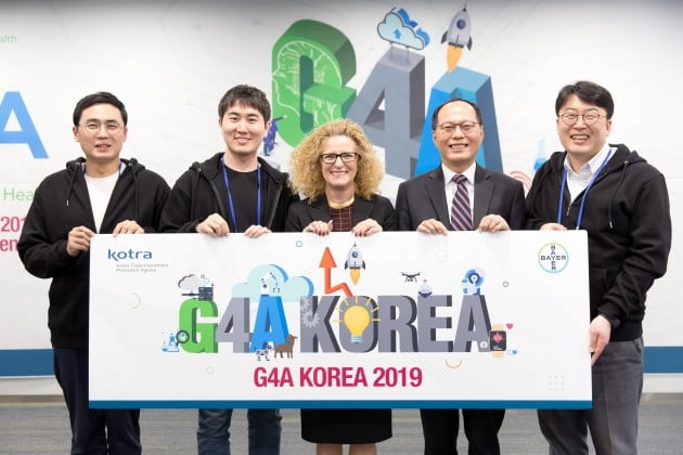 G4A 코리아 킥오프 행사에 참석한 바이엘코리아 및 KOTRA 관계자와 최종 선정팀 (왼쪽부터 임유봉 ㈜플라즈맵 대표이사, 이휘원 인핸드플러스 주식회사 대표이사, 잉그리드 드렉셀 바이엘코리아 대표이사, 선석기 코트라 중소중견기업본부장, 이병일 ㈜올리브헬스케어 대표이사). 바이엘코리아 제공