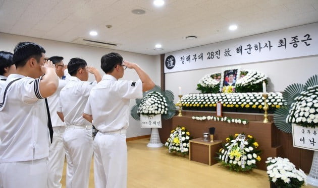 해군 장병이 25일 경남 창원시 진해구 진해 해군해양의료원에서 엄수되는 청해부대 故 최종근 하사 장례식을 찾아 경례하고 있다. [해군 제공] 