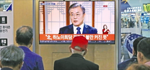 시민들이 9일 서울역에서 문재인 대통령 취임 2주년 특집 대담 ‘대통령에게 묻는다’를 TV로 시청하고 있다.  /연합뉴스 