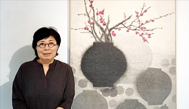 수묵화가 강미선 씨가 서울 통의동 아트사이드갤러리에 전시된 ‘홍매와 백자’를 설명하고 있다.  