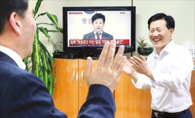 유창근 개성공단기업협회 부회장(왼쪽)과 김서진 상무가 17일 서울 여의도 개성공단기업협회에서 정부의 개성공단 기업인 방북 승인 보도를 본 뒤 환호하고 있다.  /연합뉴스 